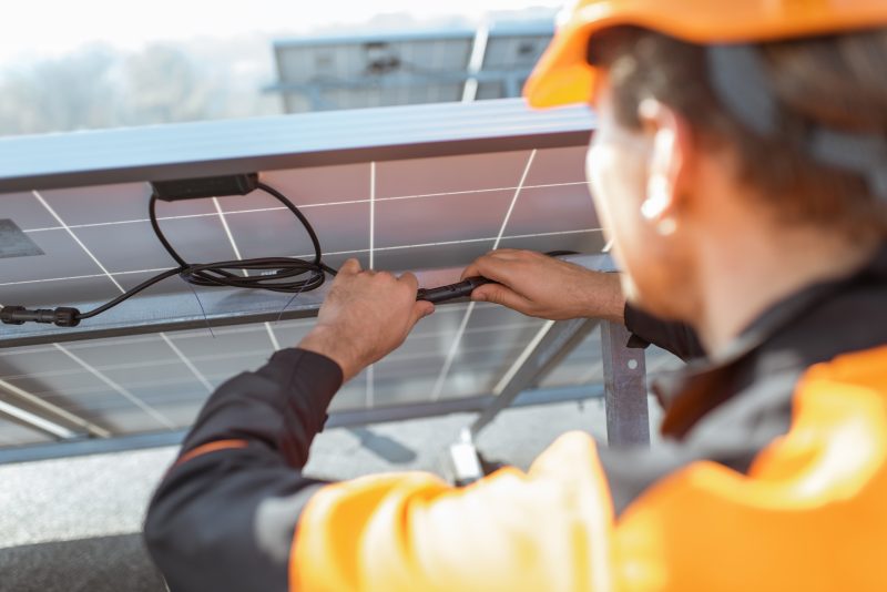electrician connecting solar panels WX3BNM3 e1632235587758 electrician connecting solar panels WX3BNM3 e1632235587758